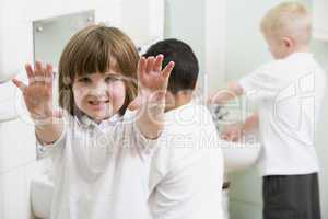 A girl displaying her hands in a primary school bathroom