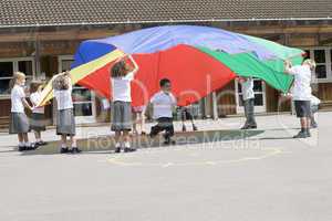Young children playing with a parachute in a playground