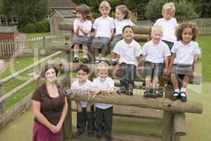 Young children and their teacher posing for a class photo