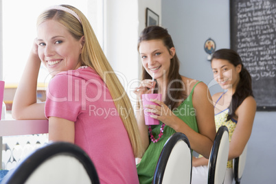 Drei junge Frauen sitzen in einem Cafè