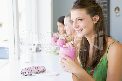 Drei junge Frauen sitzen in einem Cafè und genießen ihre Getränke