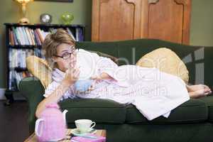 A young woman lying on her couch eating cereal