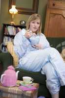 A young woman sitting on her couch eating cereal