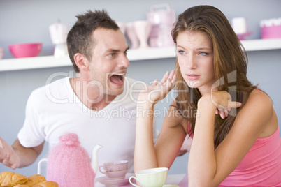 A young couple arguing at the breakfast table