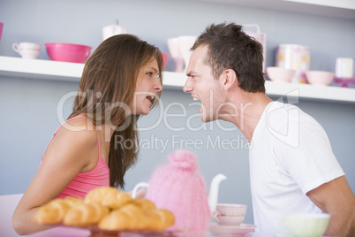 A young couple arguing at the breakfast table