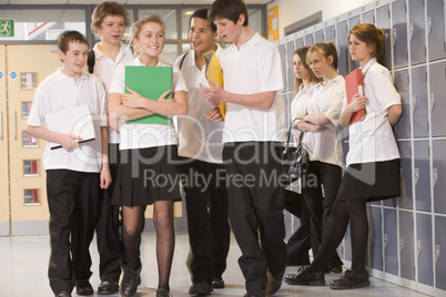 Teenage boys clustered around a girl at school