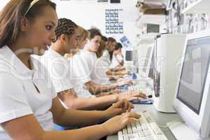 Row of schoolchildren studying in front of a computer