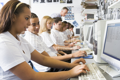 Row of schoolchildren studying in front of a computer