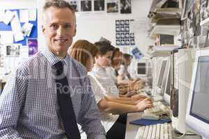 Teacher and schoolchildren studying in front of a computer