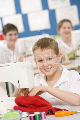 Schoolboy using a sewing machine in sewing class