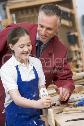 Schoolgirl and teacher in woodwork class