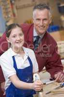 Schoolgirl and teacher in woodwork class