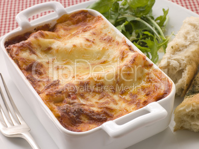 Dish of Lasgane with Salad Leaves and Italian Bread