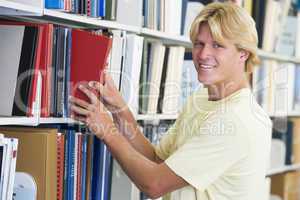 University student selecting book from library