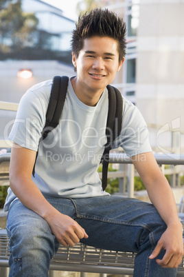 Male student sitting outside