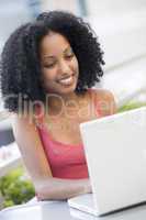 Female student using laptop computer outside