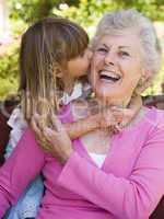 Grandmother getting a kiss from granddaughter