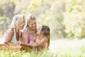 Grandmother with adult daughter and grandchild on picnic