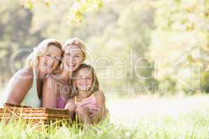 Grandmother with adult daughter and grandchild on picnic