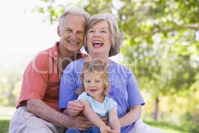 Grandparents with granddaughter in park