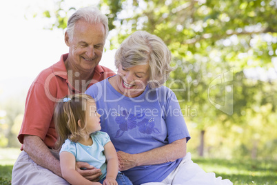 Grandparents with granddaughter in park