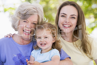 Grandmother with adult daughter and grandchild in park