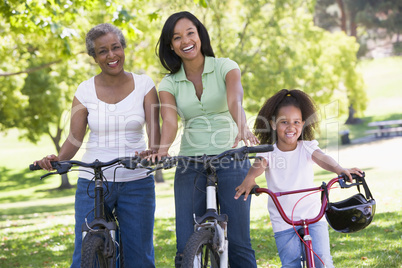 Grandmother with adult daughter and grandchild riding bikes