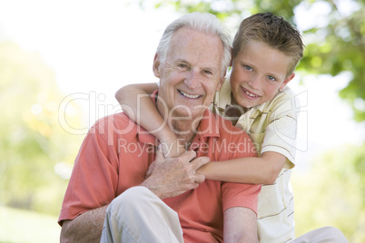 Grandfather and grandson outdoors smiling