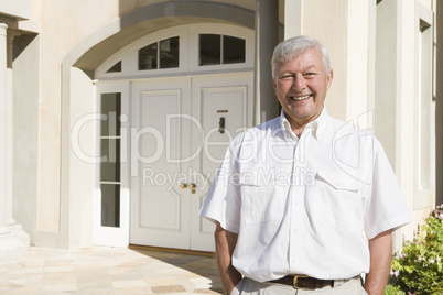 Senior man standing outside house