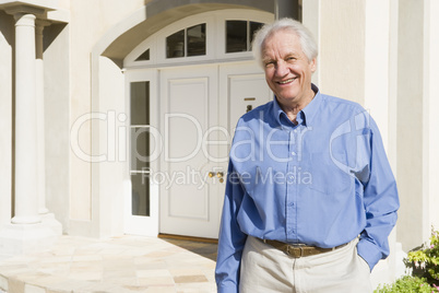 Senior man standing outside house