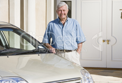 Senior man standing next to new car