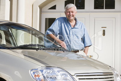 Senior man standing next to new car