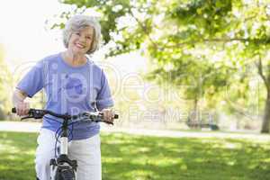 Eine ältere Frau fährt im Park Fahrrad