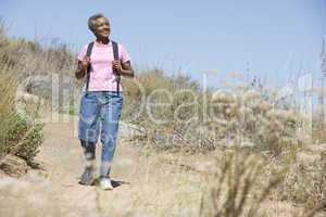 ältere dunkelhaarige Frau geht am Strand spazieren