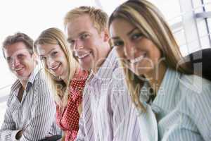 Four businesspeople sitting indoors smiling