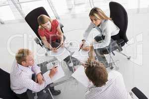 Four businesspeople in a boardroom with paperwork