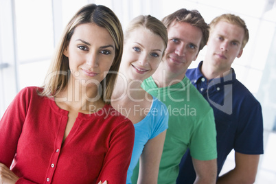 Four people standing in corridor smiling