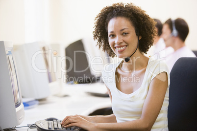 Woman wearing headset in computer room smiling