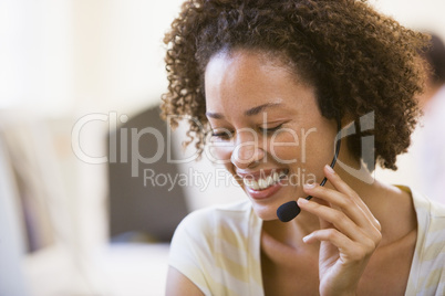 Woman wearing headset in computer room smiling