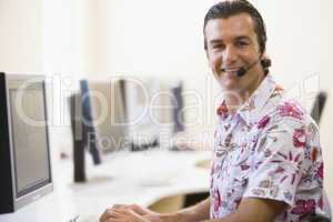 Man wearing headset in computer room smiling