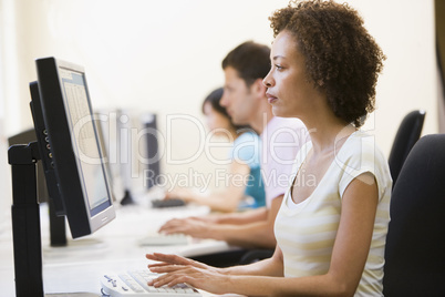 Three people in computer room typing