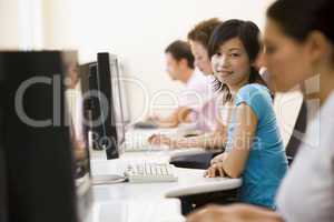 Four people sitting in computer room smiling