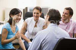 Man giving lecture to three people in computer room