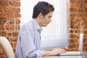 Businessman sitting in office with laptop