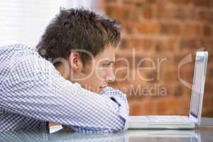 Businessman sitting in office with laptop