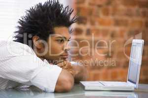 Businessman sitting in office with laptop