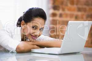 Businesswoman in office with laptop smiling