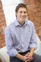 Businessman sitting in office space smiling