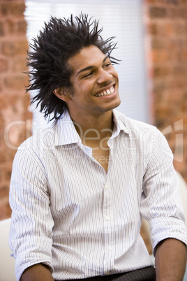 Businessman sitting in office space smiling