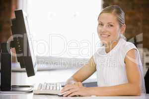 Businesswoman sitting in office with computer smiling